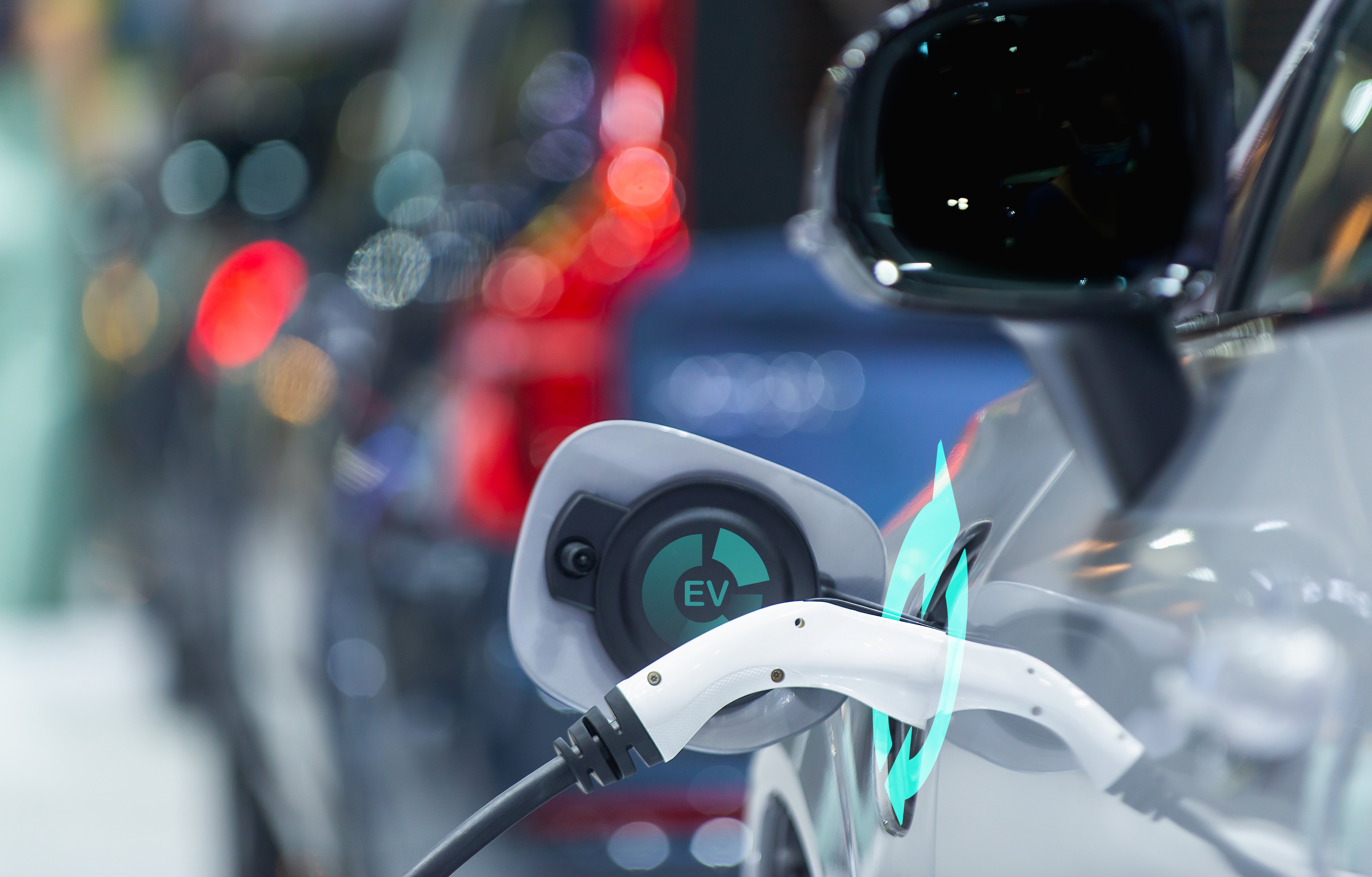 EV Car or Electric car at charging station with the power cable supply plugged in city blurred background, car fueling station connected power cable alternative sustainable eco energy