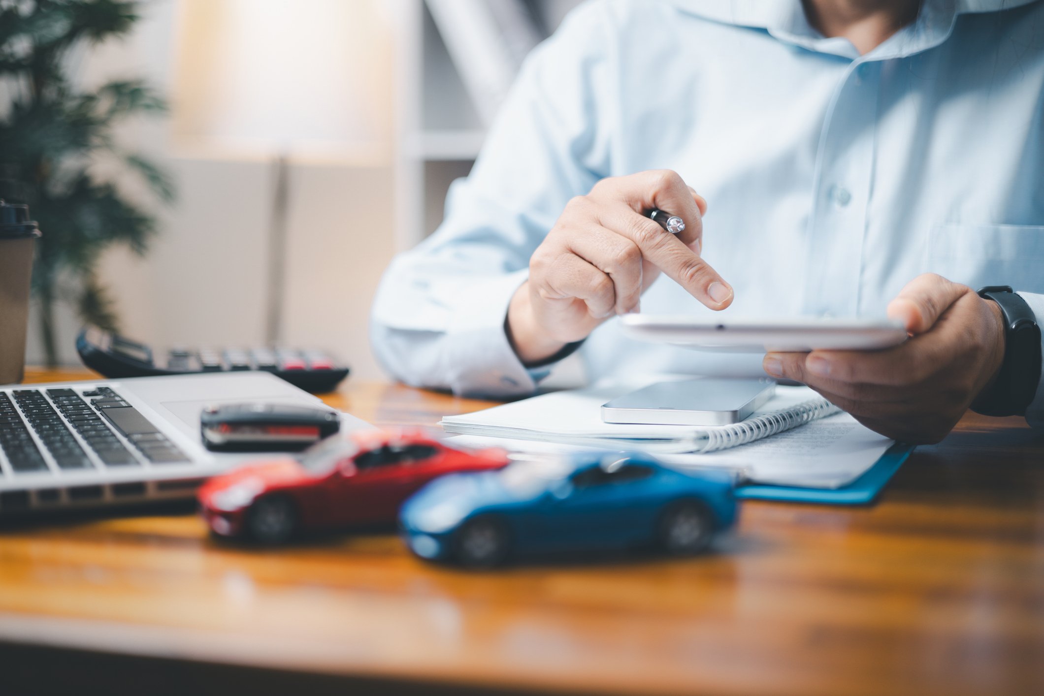 Toy Car In Front Of Businessman Calculating Loan