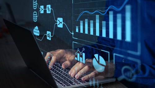 Man typing at computer with floating charts